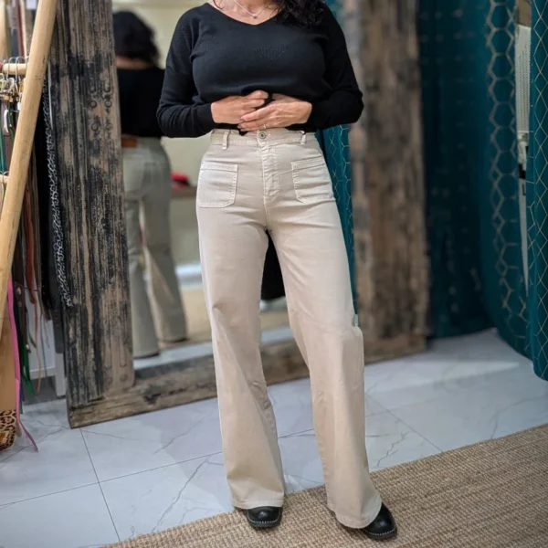 Pantalon de couleur beige, avec un pull noir, porté par un mannequin