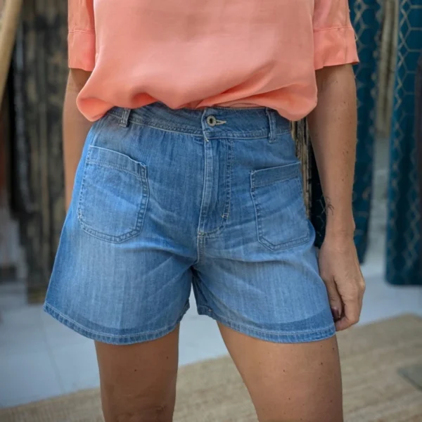 Short court de couleur bleu avec haut de couleur saumon ,porté par un mannequin