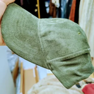 Casquette de couleur vert, porté par un main