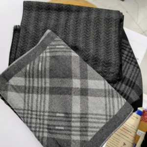 echarpe plié de couleur grise, posé sur une table