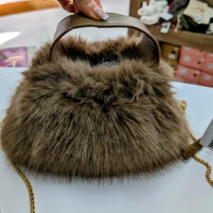 sac en fourrure de couleur beige, posé sur une table