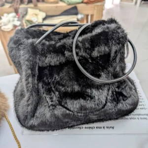 sac en fourrure de couleur noir, posé sur une table