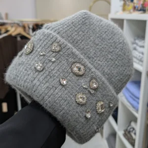 bonnet de couleur gris avec des strass, porté par une main